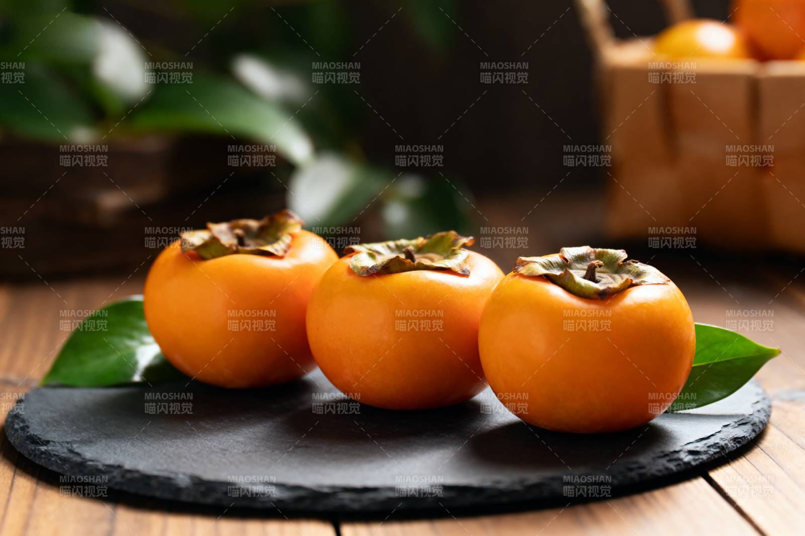 三颗柿子静置石盘图片
