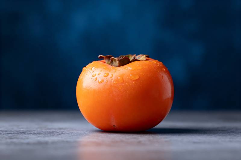 橙色柿子静置桌面图片