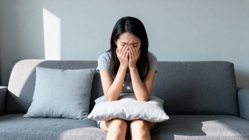 女子沙发掩面哭泣图片