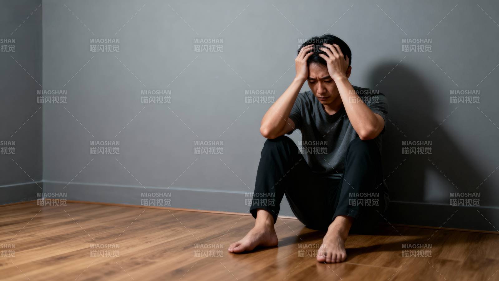 男子靠墙低头抱头图片