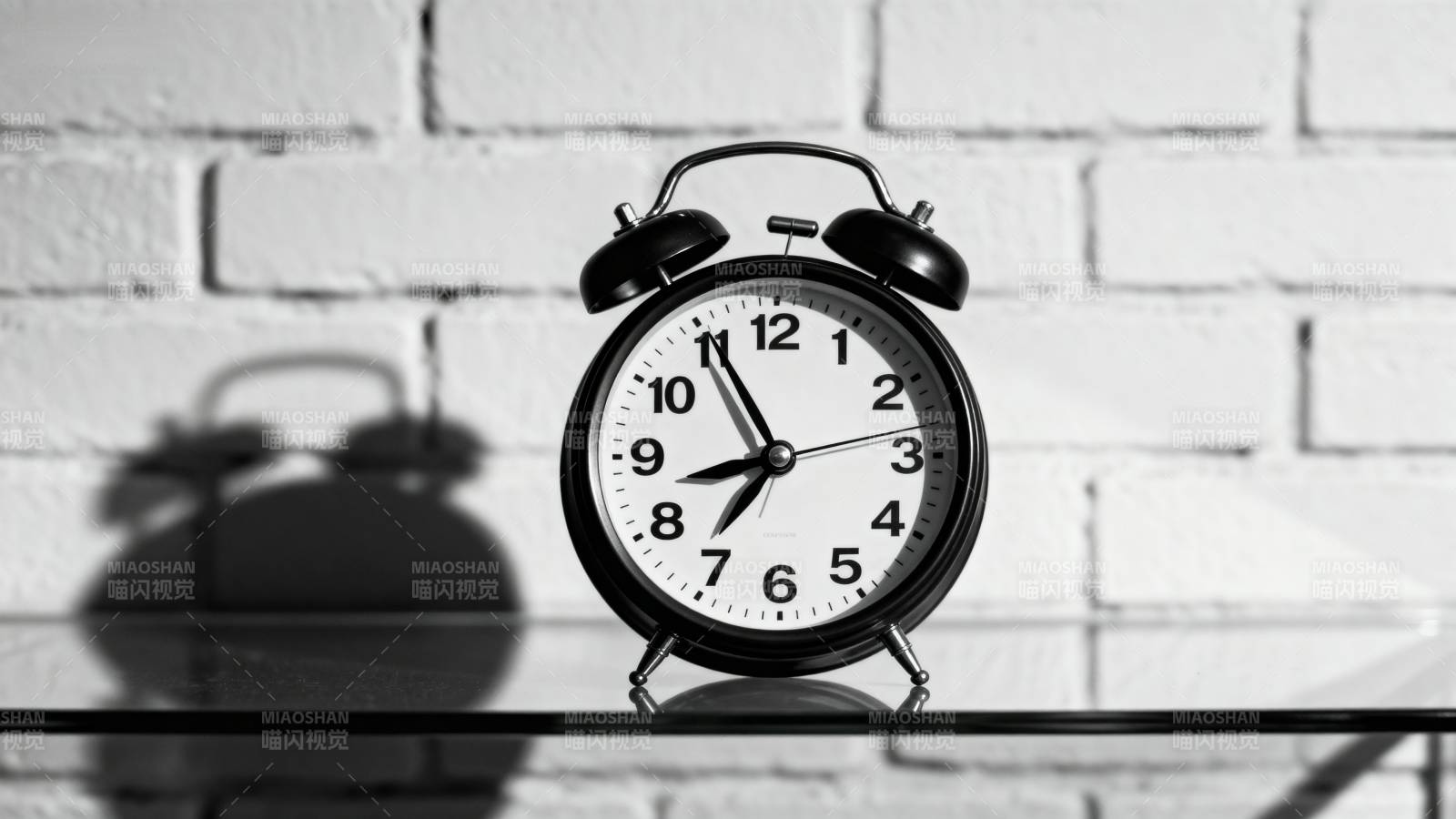 闹钟静置砖墙前图片