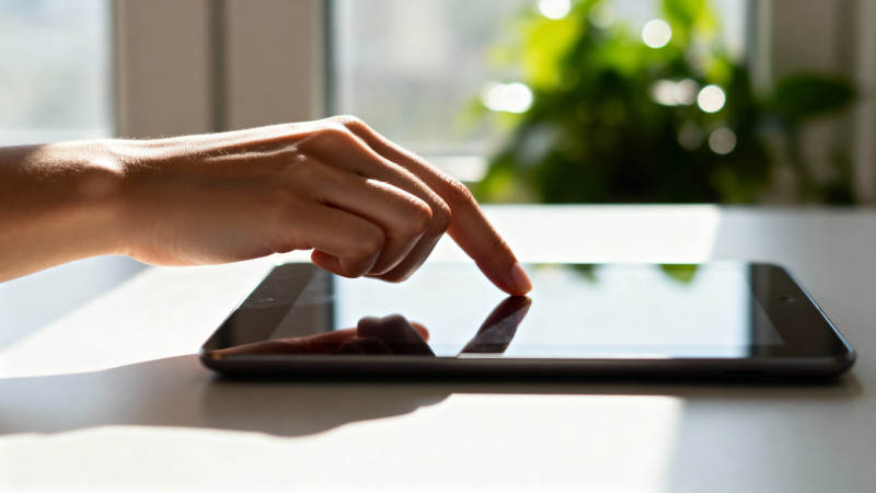 手指轻触平板屏幕图片