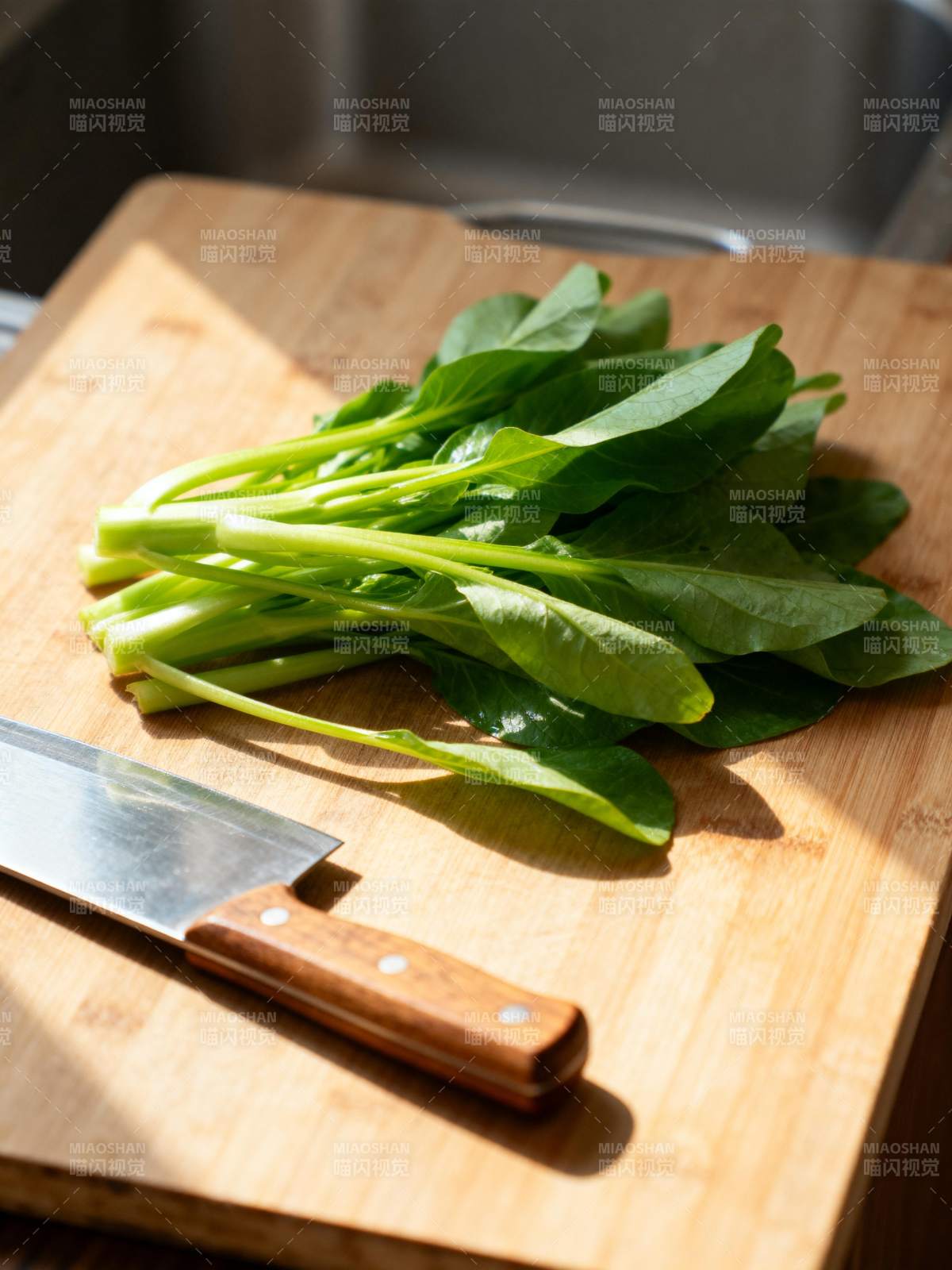 青菜与刀具静置砧板图片