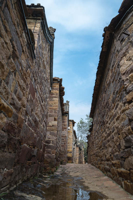 古巷石墙映蓝天图片