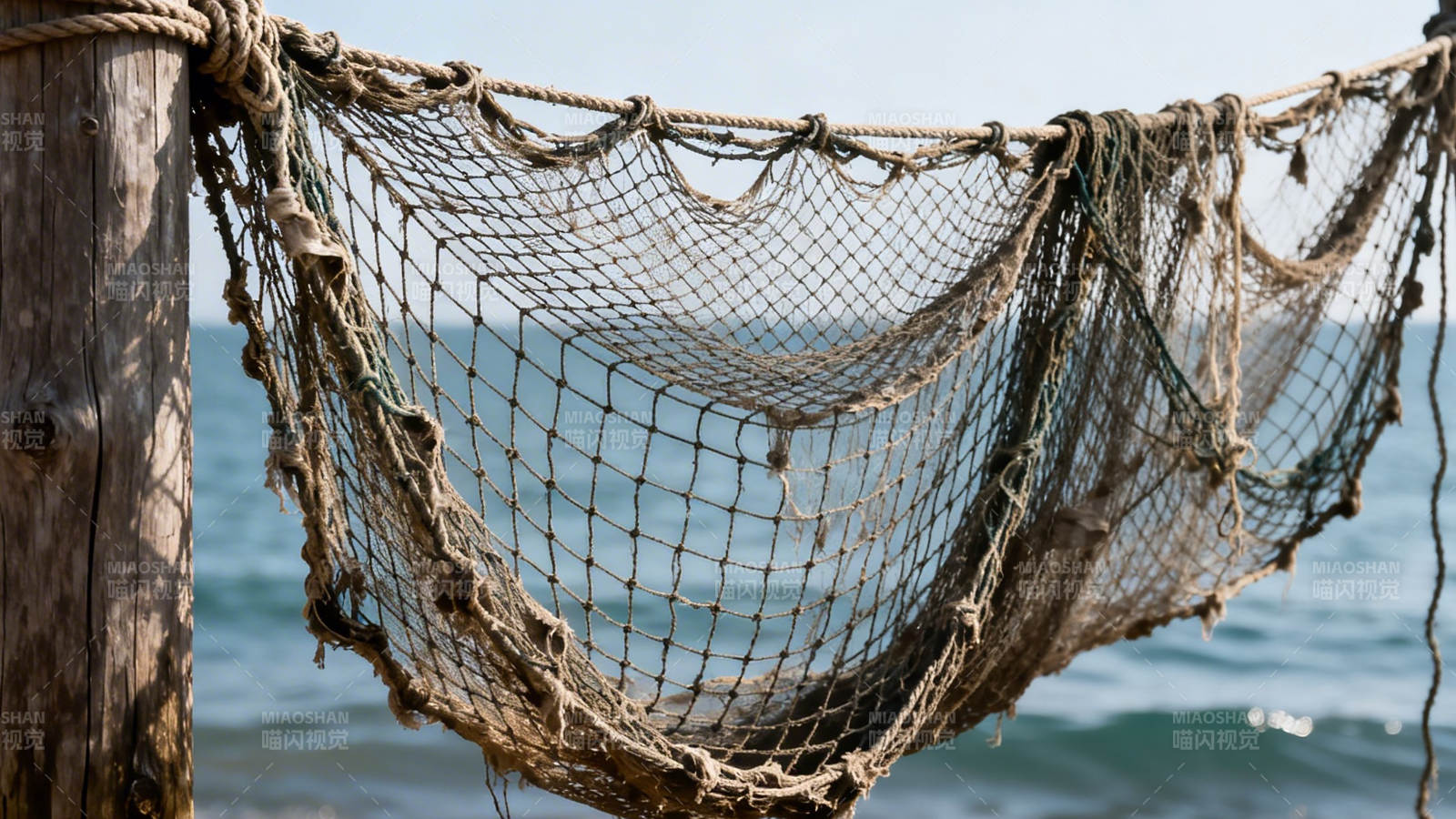 渔网悬于海边木桩图片