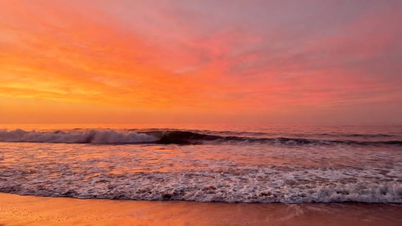 夕阳海浪映沙滩图片