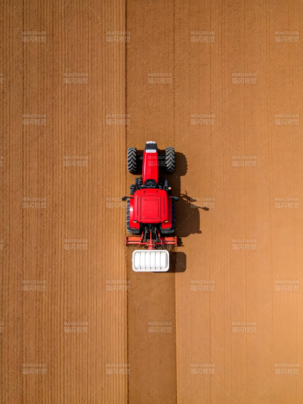 俯瞰红色拖拉机耕作图片
