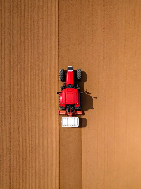 俯瞰红色拖拉机耕作图片