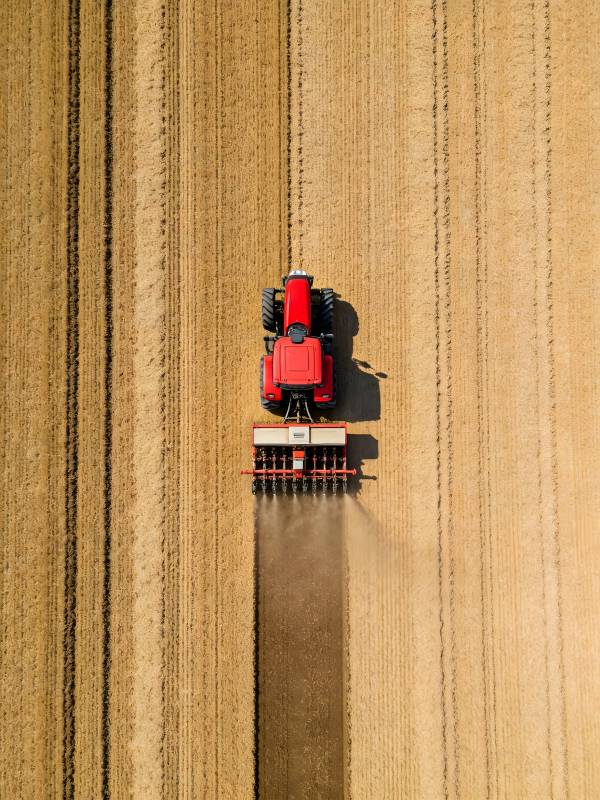 俯瞰耕田的红色拖拉机图片