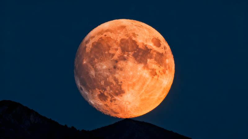 橙月升山巅图片