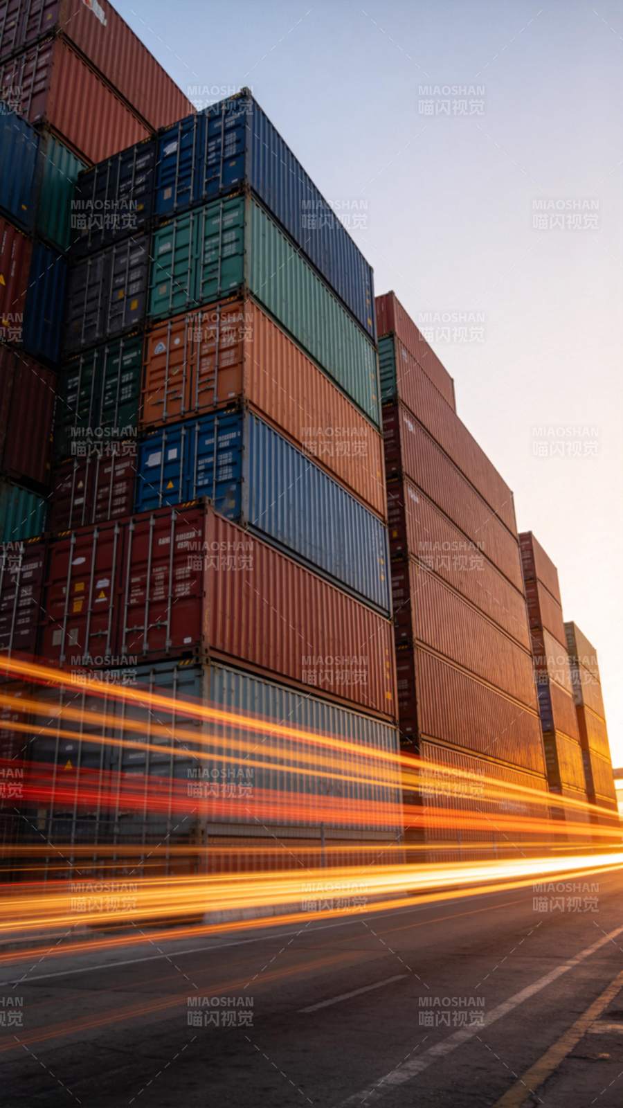 集装箱堆场旁车流光轨掠过黄昏道路图片