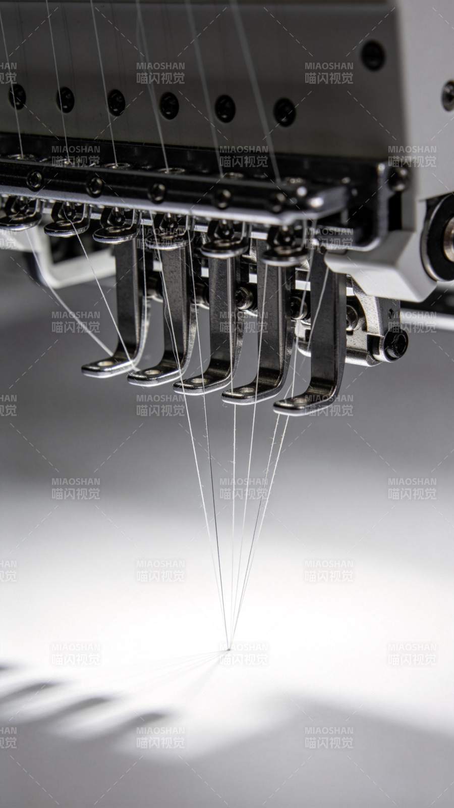 工业绣花机多针头同步刺绣作业特写图片