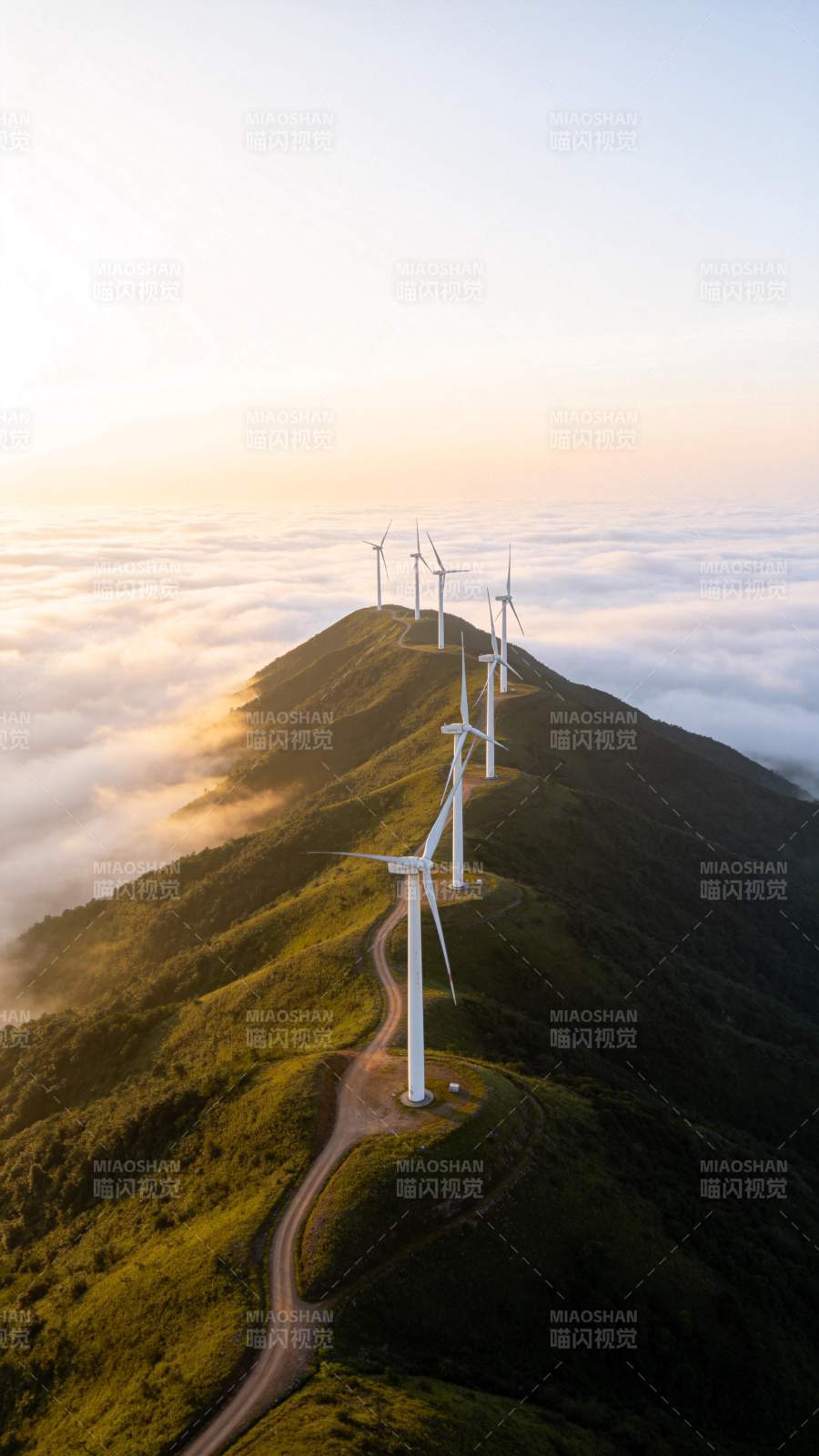 山脊线上排列的风力发电机群与云海日出景象图片
