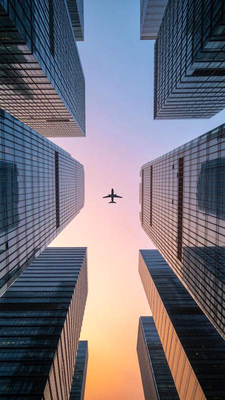 高楼林立间飞机飞越城市天际线图片