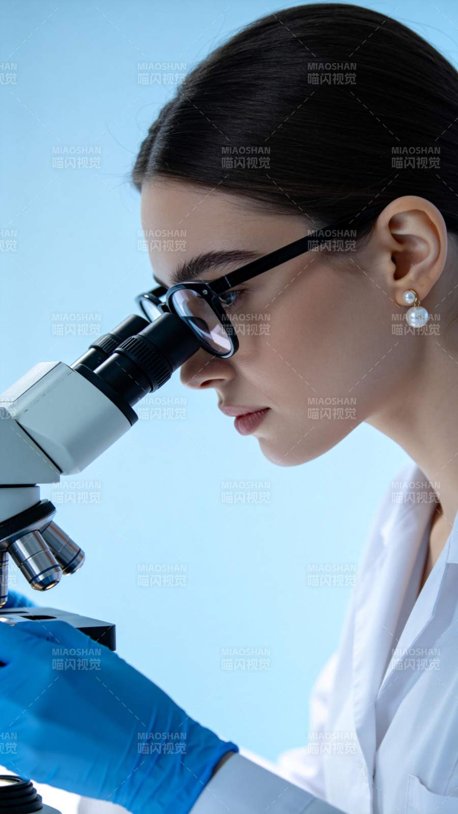女性科研人员佩戴眼镜使用显微镜进行观察图片