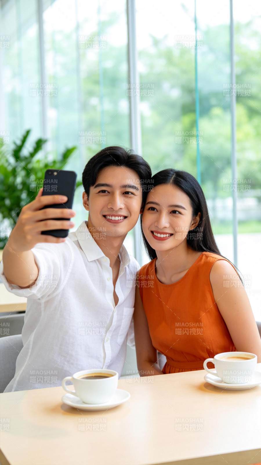 男女在咖啡馆用手机自拍合影图片