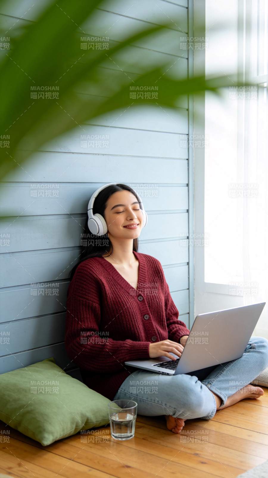 女子戴耳机坐地使用笔记本电脑图片