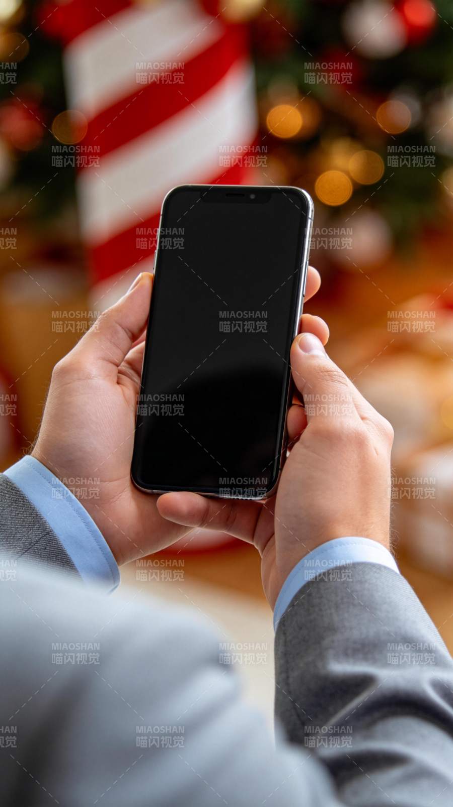 双手持黑色智能手机背景为圣诞装饰图片