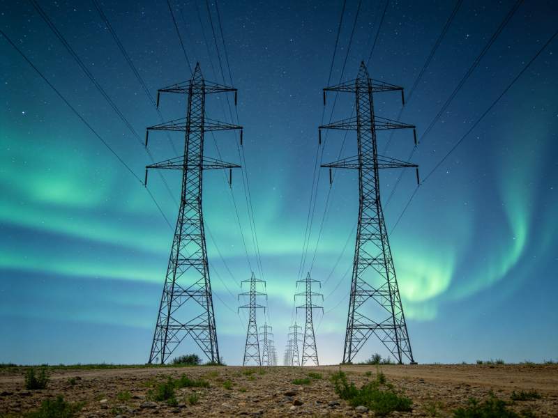 高压输电塔下极光闪耀夜空景象图片