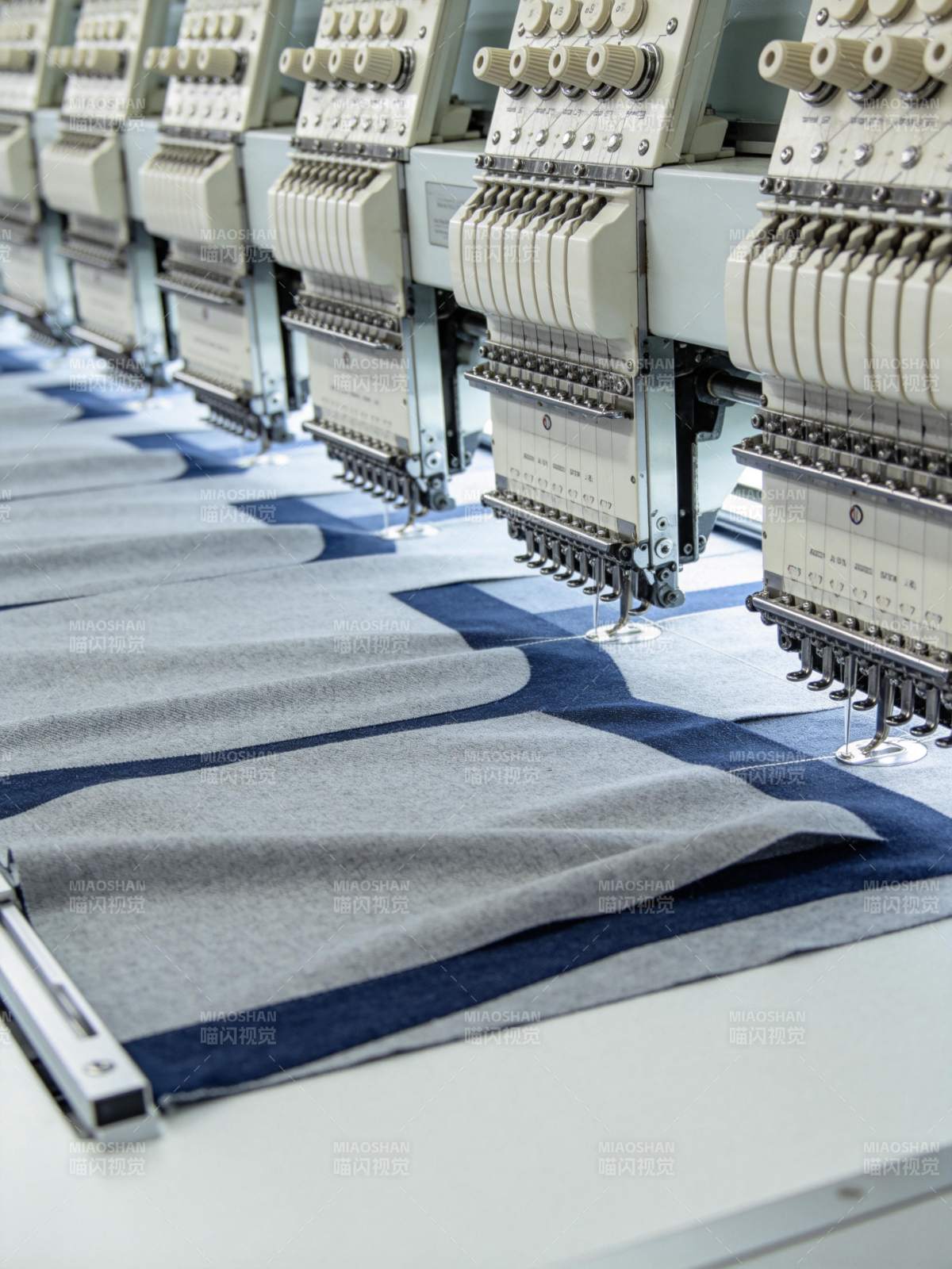 多台工业绣花机正在自动刺绣布料图片