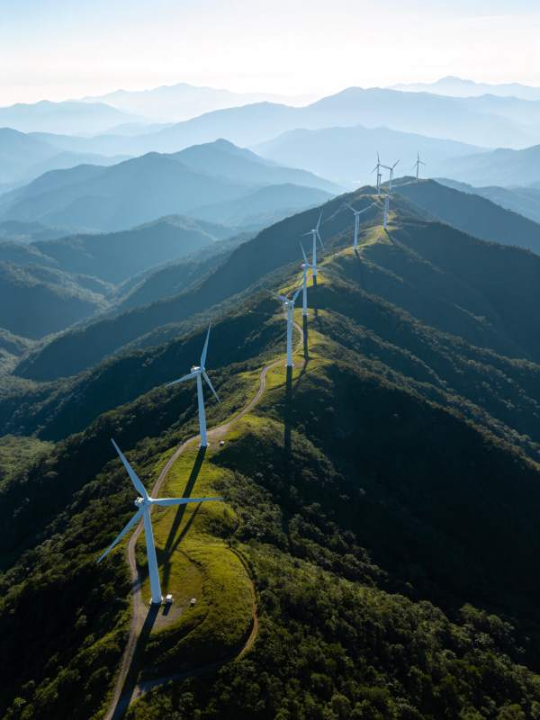 山脊线上排列的白色风力发电机群图片