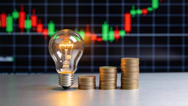 灯泡与金币前的股市图图片