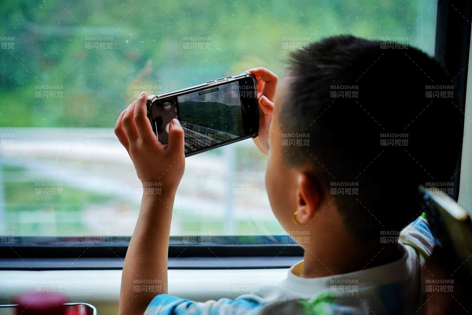 窗边拍照的小男孩图片