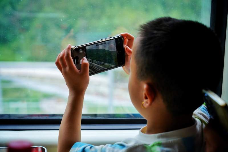 窗边拍照的小男孩图片