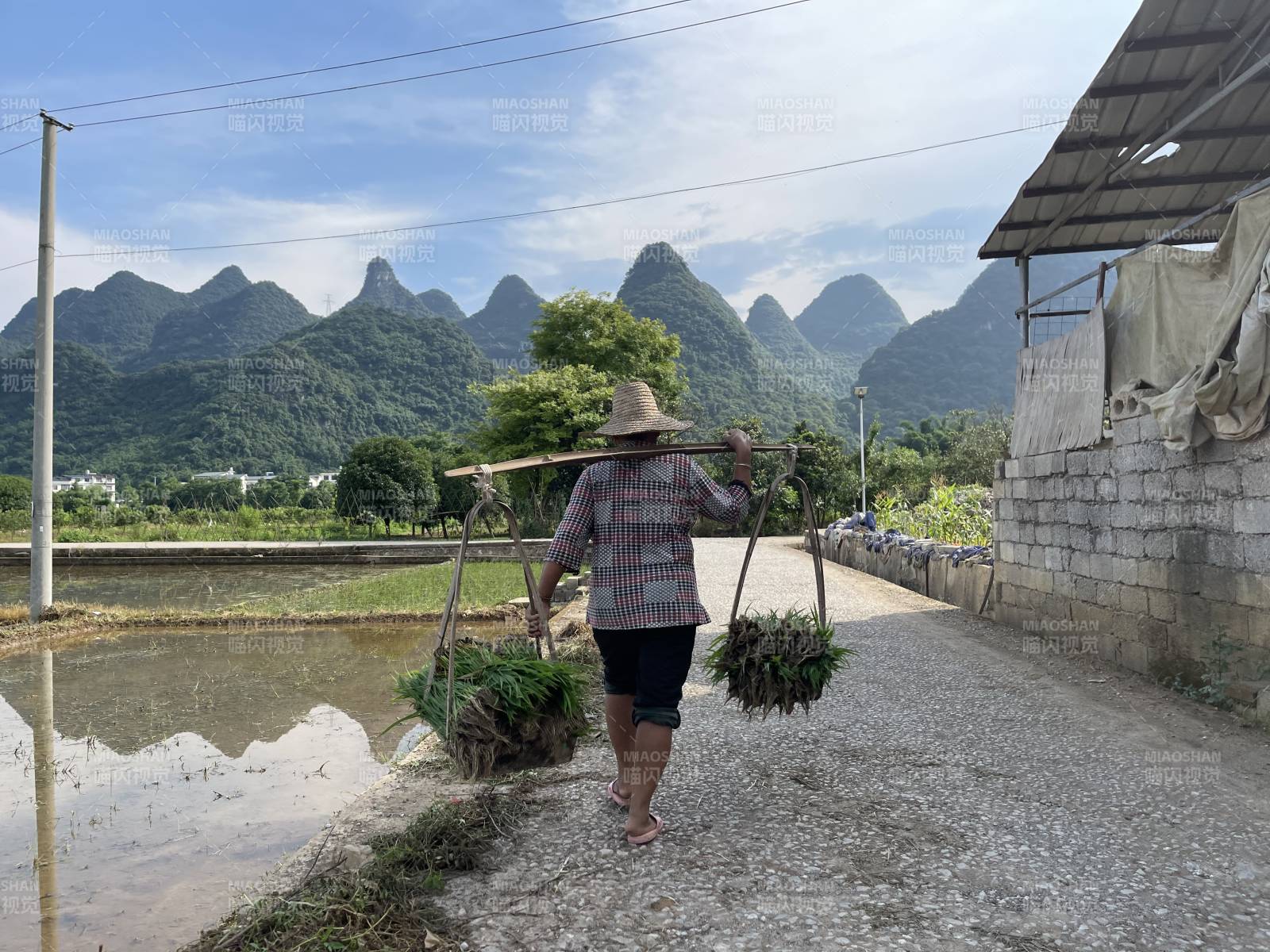 挑担农妇行于山水间图片