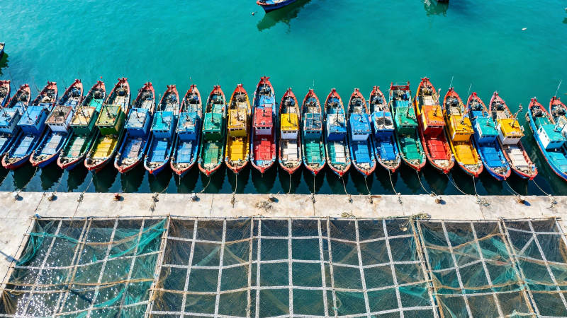 彩色小船排排坐 碧海如镜映彩虹图片