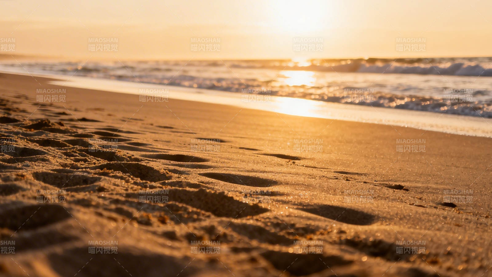 夕阳沙滩 脚印映金辉图片