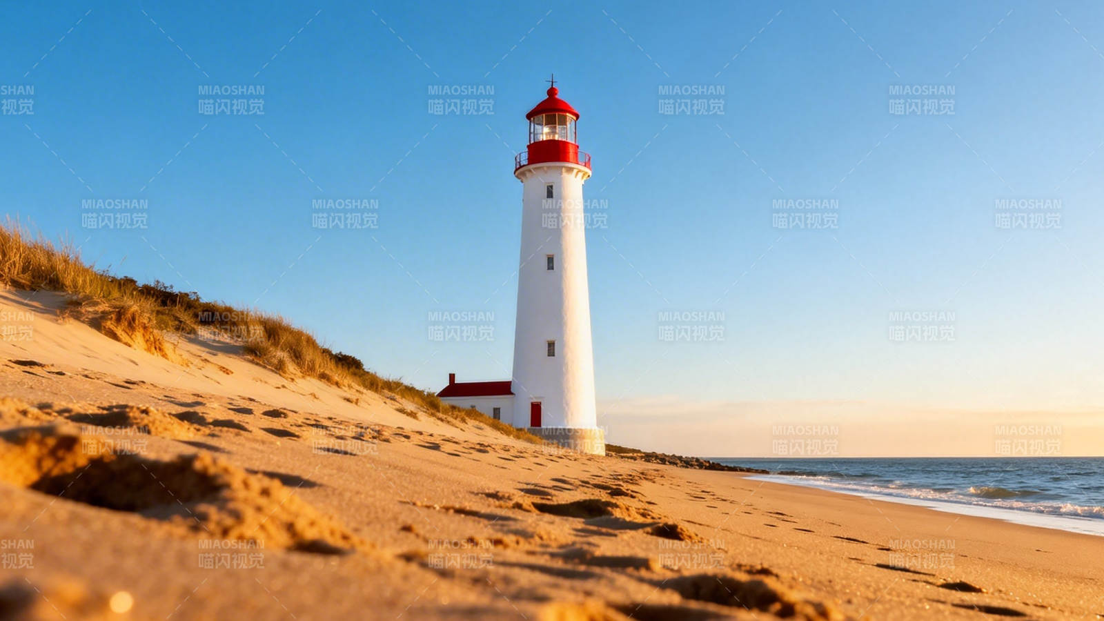沙滩红顶灯塔迎夕阳图片