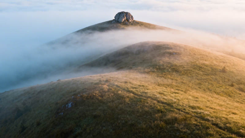 雾绕山巅 孤石静立晨光中图片