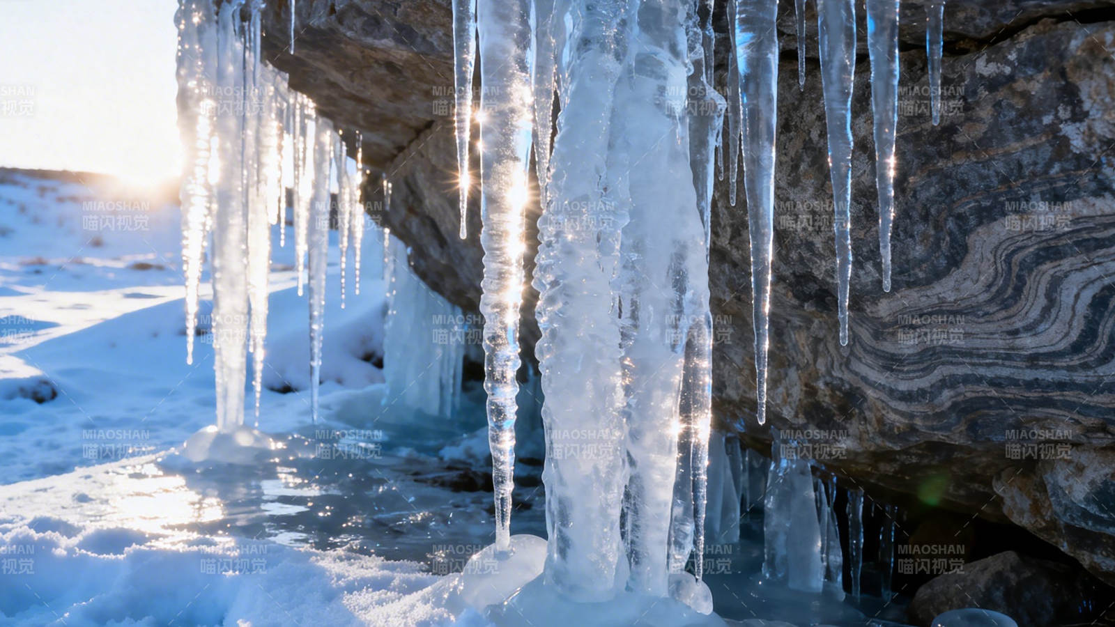 冰柱垂挂 阳光映雪岩图片