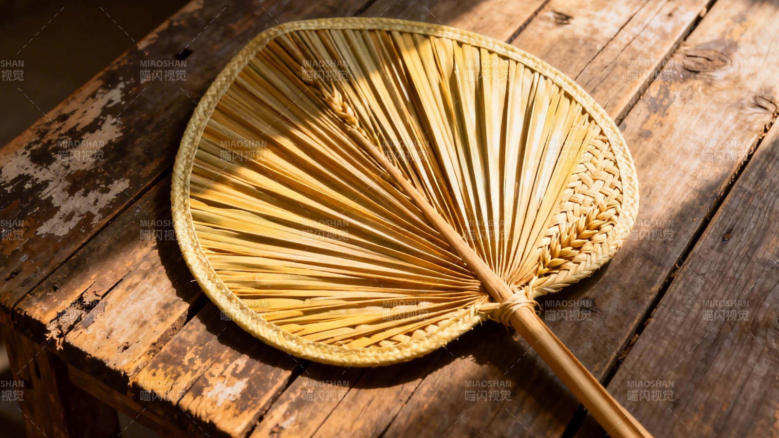 竹扇静置木桌 光影斑驳图片
