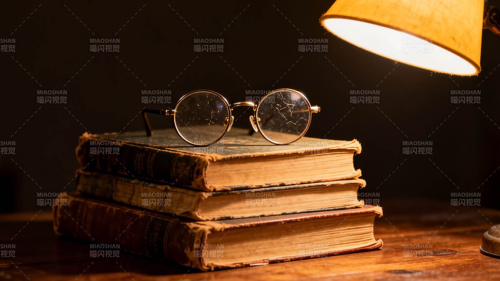 古书叠放 眼镜静置灯下图片