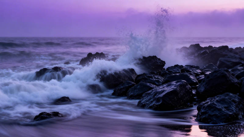 紫霞海浪拍礁石图片