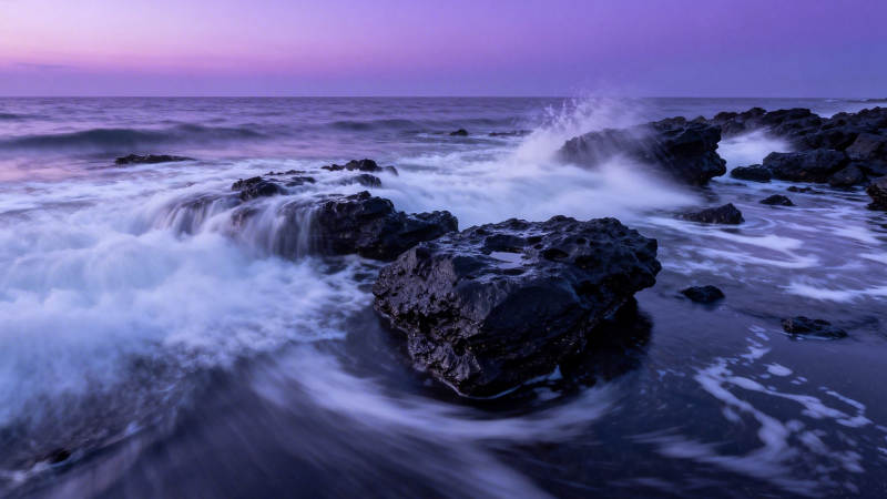 紫霞海浪拍礁石图片