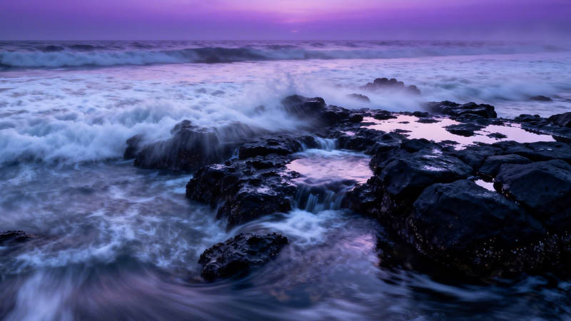 紫霞海浪拍礁石图片