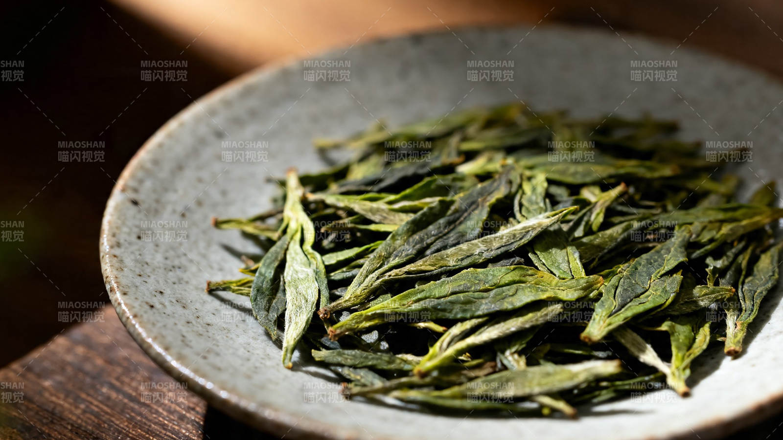 青瓷盘盛嫩绿茶芽图片