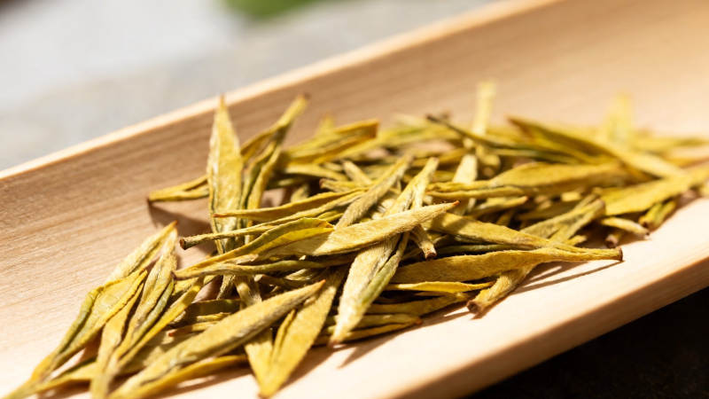 金黄茶芽静卧木盘上图片