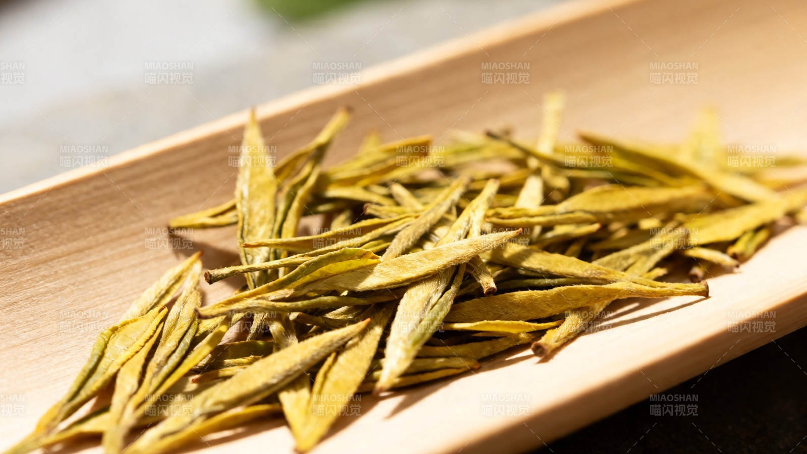 金黄茶芽静卧木盘上图片