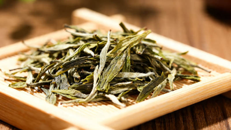 竹盘盛放嫩绿茶叶图片