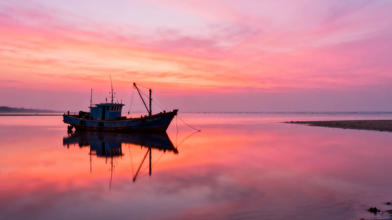 夕阳渔船静泊水面图片
