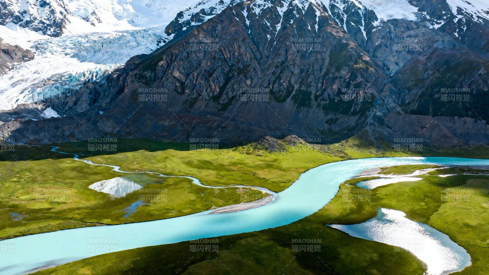 冰川融水蜿蜒绿野间图片