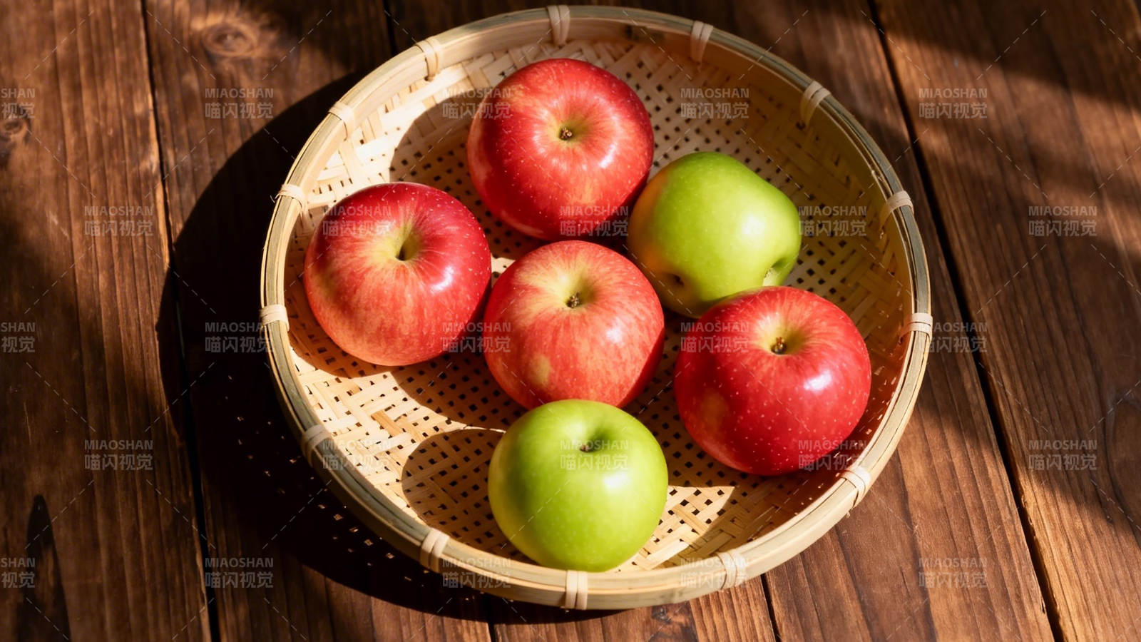 竹篮红绿苹果 阳光木纹桌图片