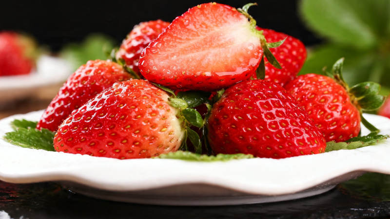 鲜红草莓堆满白盘 诱人欲滴图片