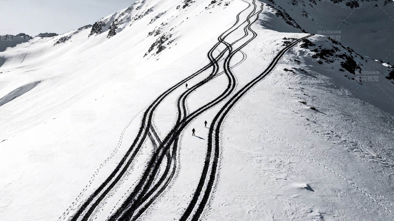 雪山蜿蜒雪道 几人滑行中图片
