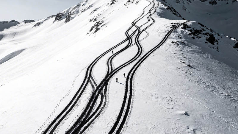 雪山蜿蜒雪道 几人滑行中图片