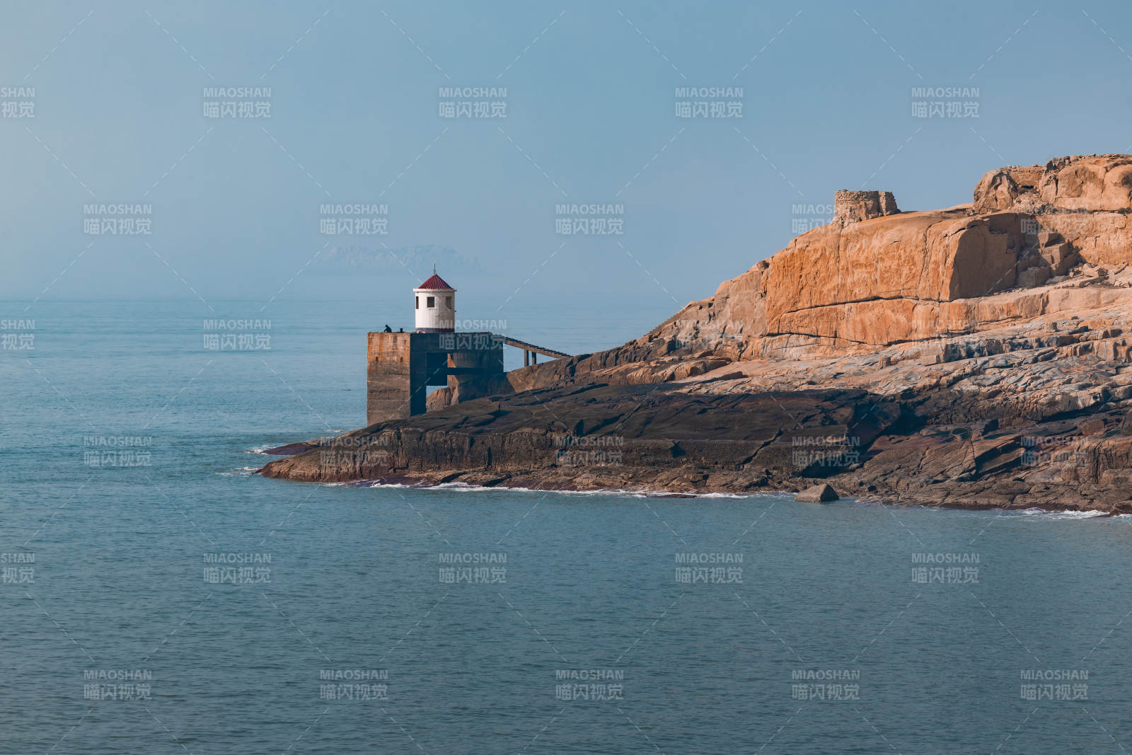 海边灯塔与红岩峭壁图片